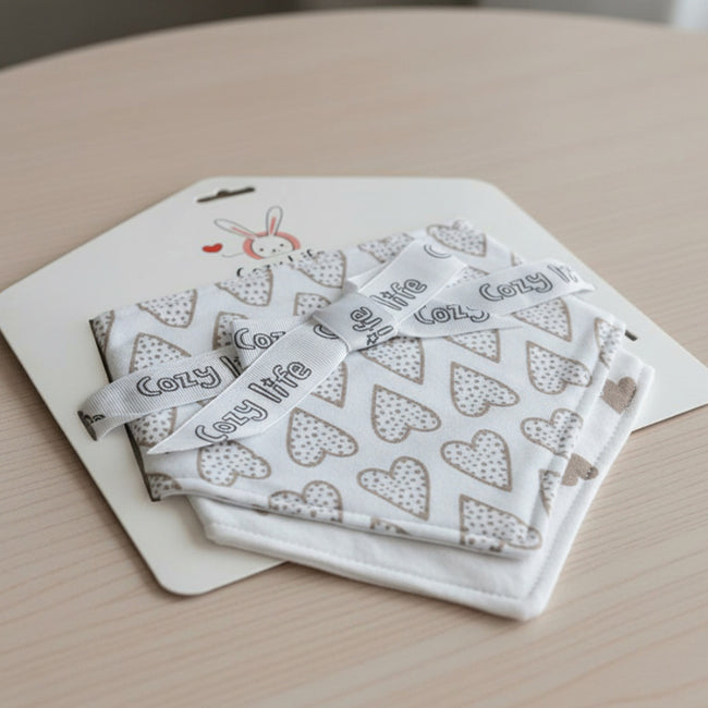 Cotton Bandana Hearts Baby Bib in card packaging on a table
