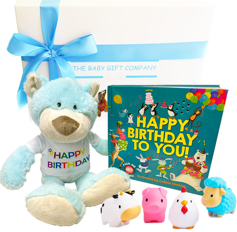 Gift set with blue teddy bear, colorful book, and small plush toys on a white background.