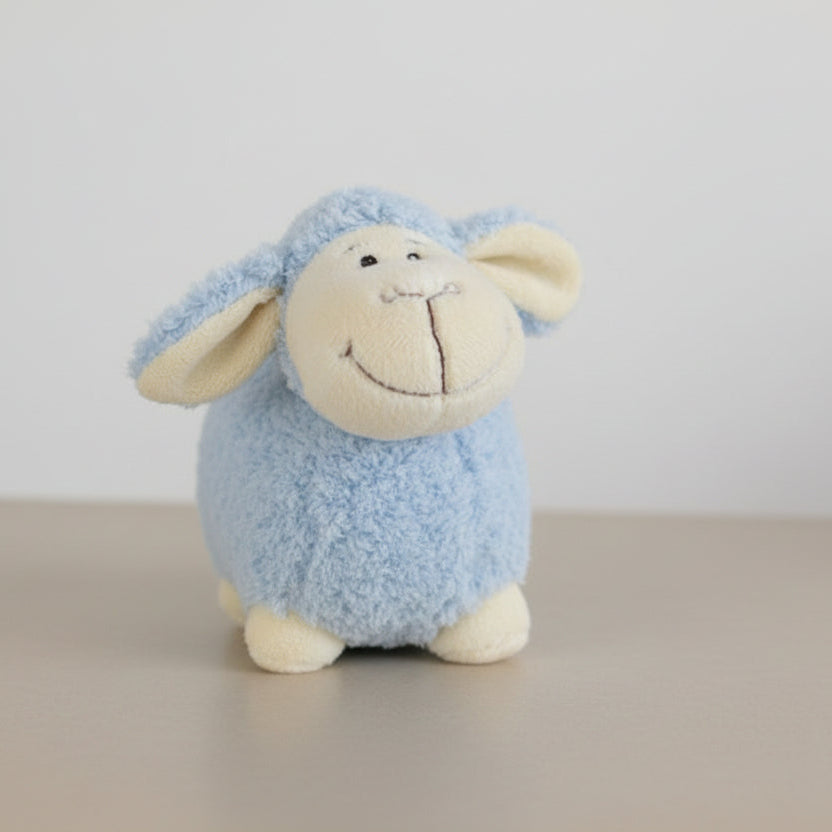 Blue plush sheep toy on a white background