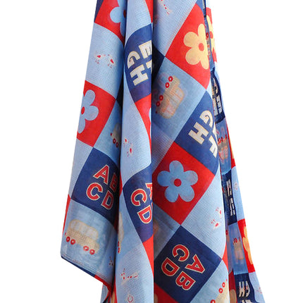 Colorful muslin wrap with alphabet and flower patterns on a white background