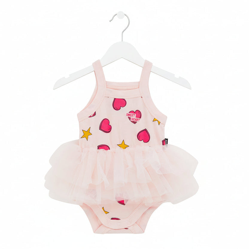 Pink baby romper with heart and star patterns on a white background