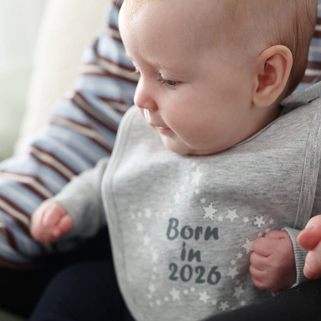 Baby wearing grey 'born in 2026' bib