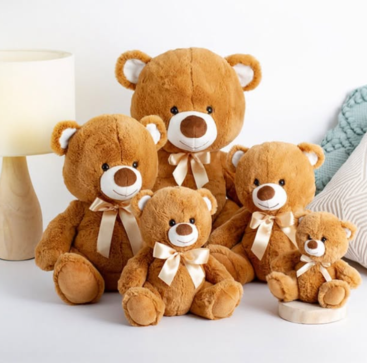 Set of brown teddy bears with white bows on a light background
