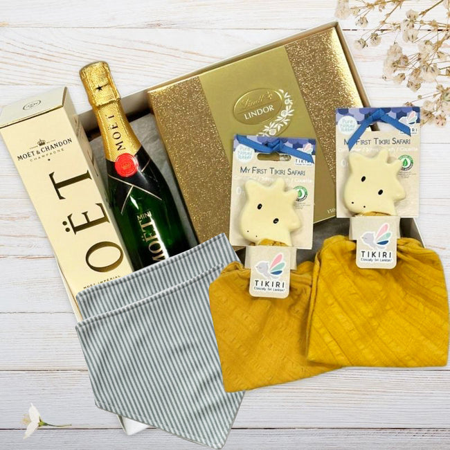 Baby gift set with giraffe toys, moet, chocolate, and other items from The Baby Gift Company. 