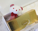 Small plush toy with red and white striped details on a Lindor chocolate box.