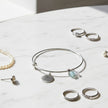 Cool Mum Bangle featuring a sentiment charm with other jewellery on table