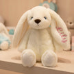 Personalised embroidered bunny plush toy with baby's name, sitting table