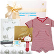 Baby gift set with striped romper, blanket, and Lindt chocolate, branded 'The Baby Gift Company'.