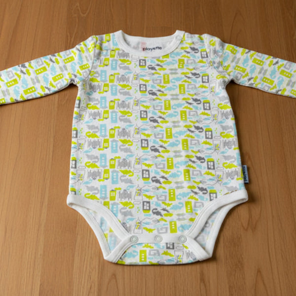 Baby onesie with vehicle pattern on a wooden table background