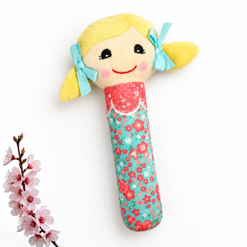 Baby doll toy with blond hair on table