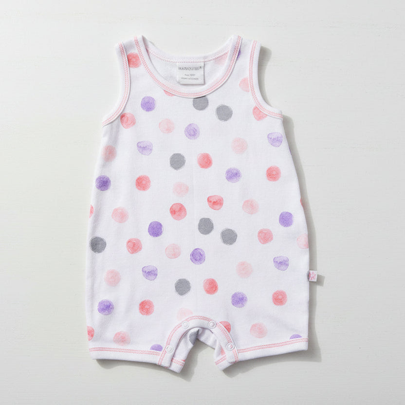Baby romper with colorful dot pattern on a table background