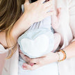Person holding a baby's foot with a heart-shaped object