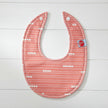 Baby bib with red and white pattern on a white background