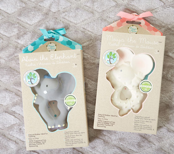 Two elephant-shaped toys in their packaging on a textured surface