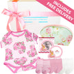 Baby gift set with floral onesie, socks, and other items from The Baby Gift Company.