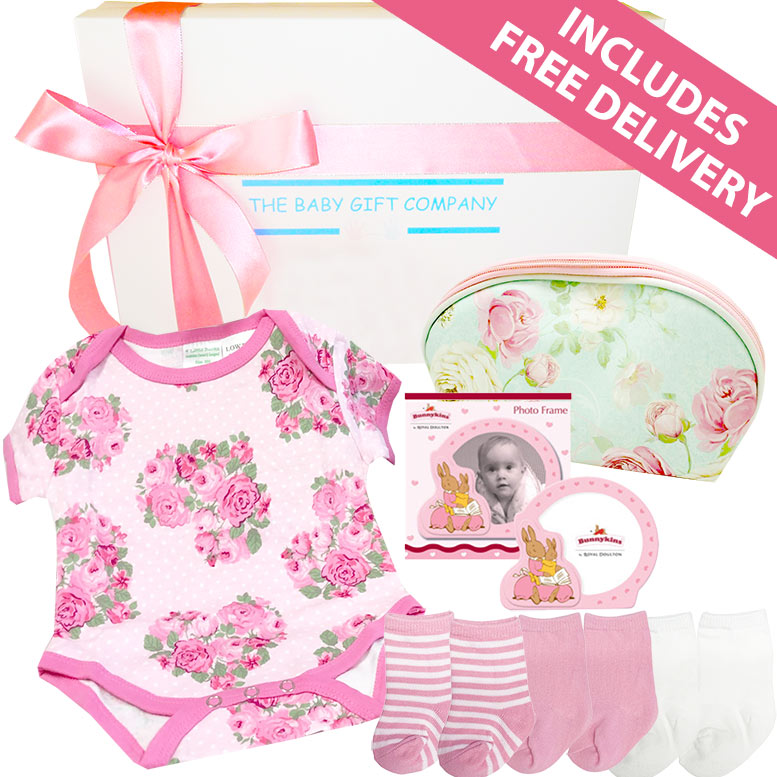 Baby gift set with floral onesie, socks, and other items from The Baby Gift Company.