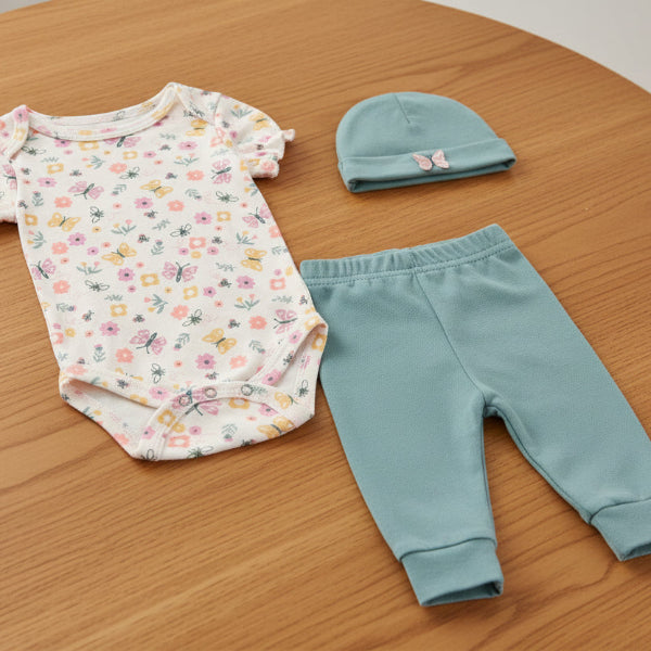 Baby clothing set with floral bodysuit, teal pants, and hat on a white background