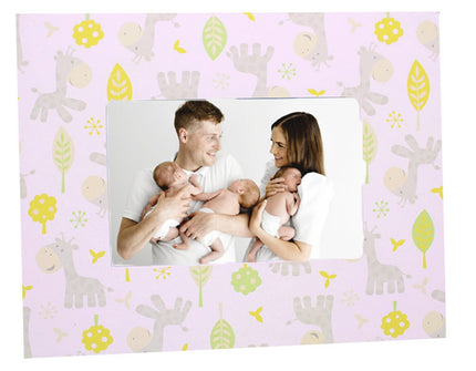Family holding two babies with a decorative frame featuring animal patterns on a pink background