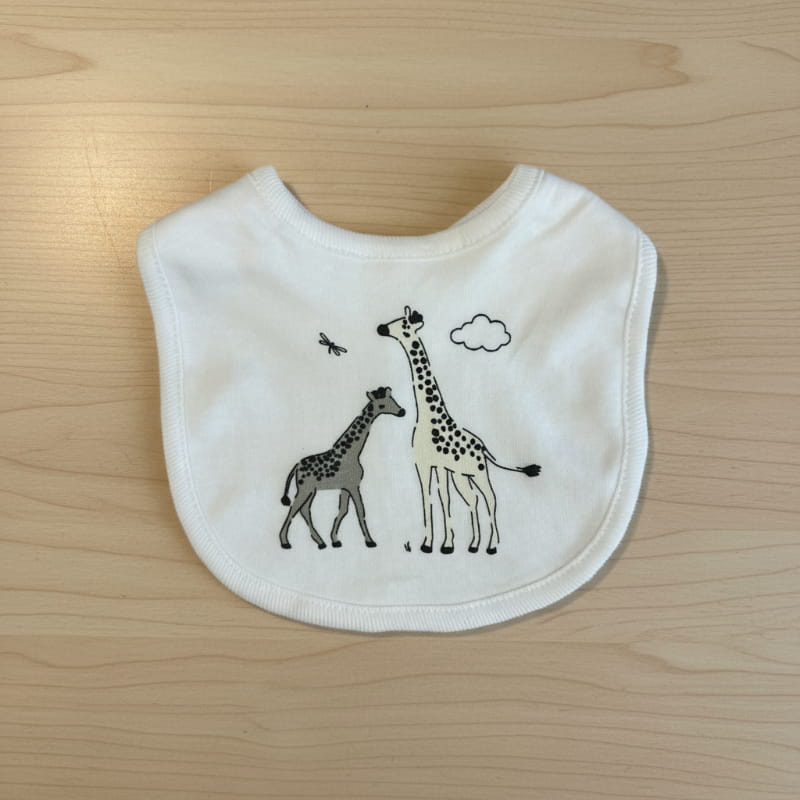 white baby bib with two giraffe printed on wooden table