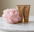 Golden body lotion and body wash set with pink wash sponge
