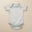Gray baby onesie with a subtle pattern on a table