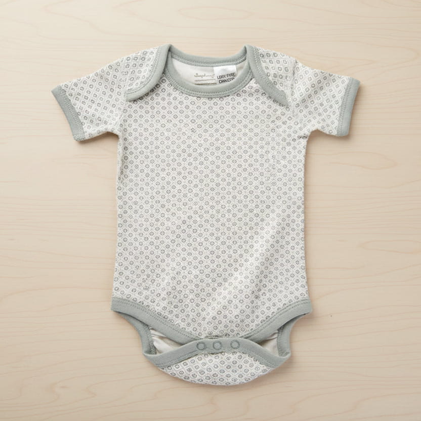 Gray baby onesie with a subtle pattern on a table