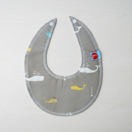 Grey bib with whale patterns on a table background