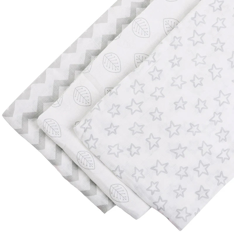 Grey and white 3-piece muslin wraps set on a table surface
