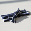 Navy and white striped headband with a knot on a white background