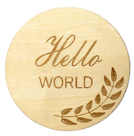 Round wooden token with 'Hello World' engraving on a white background
