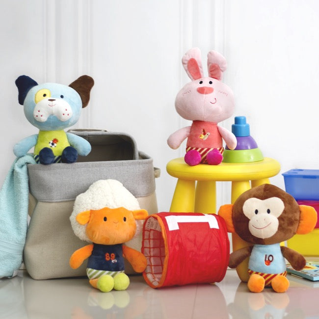 Colorful plush toys including a dog, rabbit, monkey, and sheep on a light background.