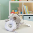 Plush elephant toy with a white ring on a surface in nursery