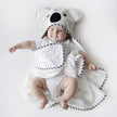 Baby laying down wearing a hooded koala towel