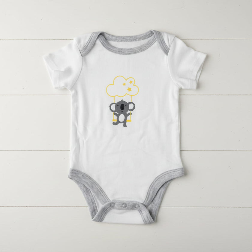 White and grey Koala baby romper on table