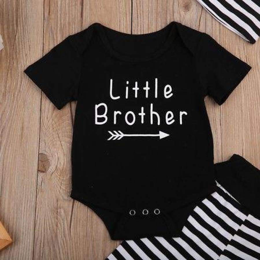 Black baby onesie with 'Little Brother' text on a wooden surface