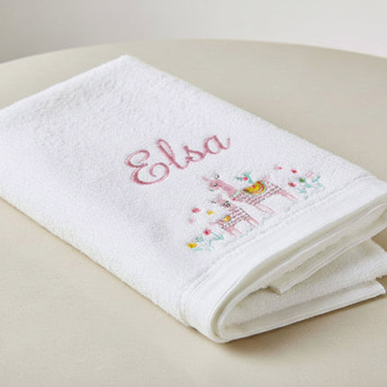 White towel with embroidered baby name and llamas on a white background