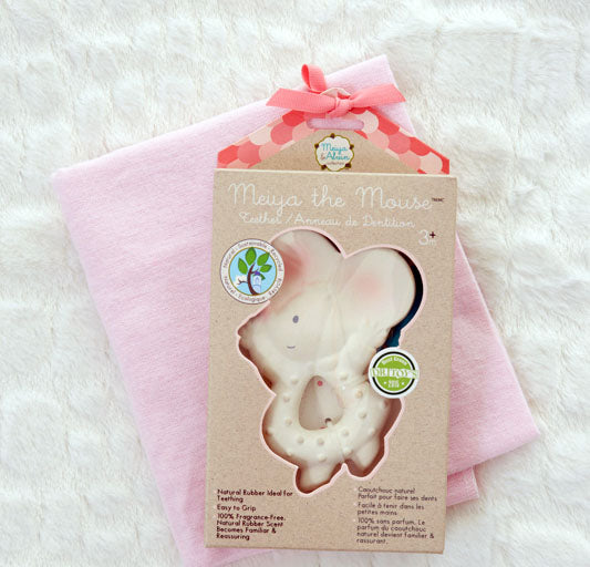 Teething toy with packaging and pink cloth on a white background