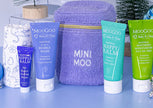 Set of Moogoo Baby & Child skincare products including bubbly wash, balm, moisturizer, and nipple balm with a baby blanket.