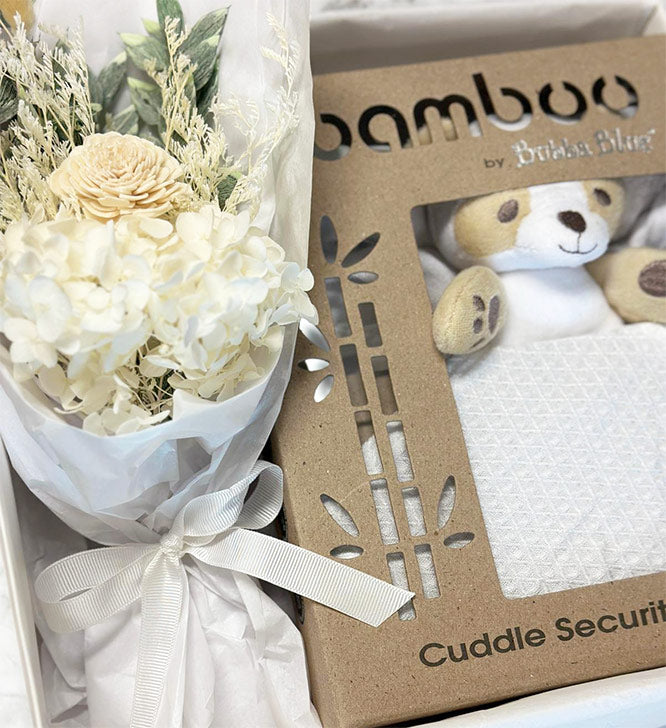 Bouquet of white flowers and 'Bamboo Baby toy' with a teddy bear image in gift box