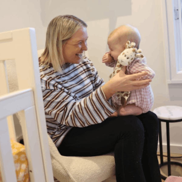 Mum holding baby with Giraffe Doudou toy