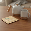 Wooden nana coaster on a table with a tea pot and mug