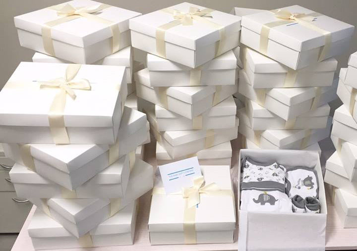 New baby gift hampers in white gift boxes with ivory ribbons 