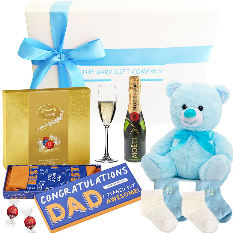Gift set with teddy bear, champagne, Lindt chocolate, and socks with a 'Congratulations Dad' card.