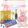 Gift set with pink teddy bear, Lindt chocolate, Moet champagne, and baby socks with 'Congratulations Dad' socks.