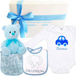 Baby gift set with blue teddy bear, bib, and bodysuit with car design, branded 'The Baby Gift Company'.