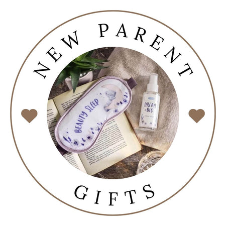 New parent gifts including a sleep mask and bottle on a textured surface with 'NEW PARENT GIFTS' text.