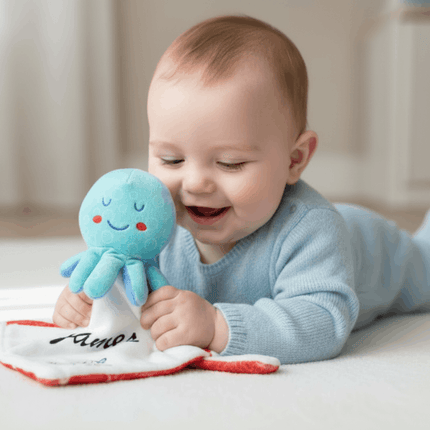 baby holding blue octopus toy
