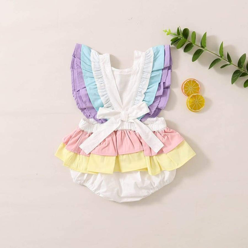 Pastel-colored baby outfit with ruffled details on a light background