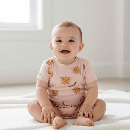 Baby sitting on floor wearing bonds romper