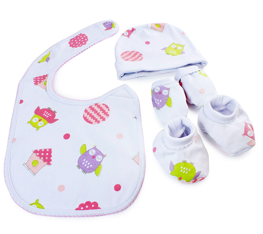 Baby bib, hat, and booties set with owl pattern on a wooden background